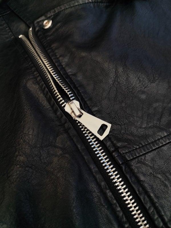 Metal zipper detail on textured leather bag
